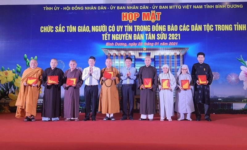 Ông Võ Văn Minh và ông Nguyễn Văn Lộc trao tặng Cờ Tổ quốc cho đại diện các tôn giáo tại lễ họp mặt