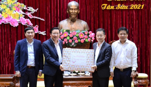 Trưởng ban Nội chính Trung ương Phan Đình Trạc (thứ 2, trái sang) tặng quà và gửi lời chúc mừng năm mới thành phố.