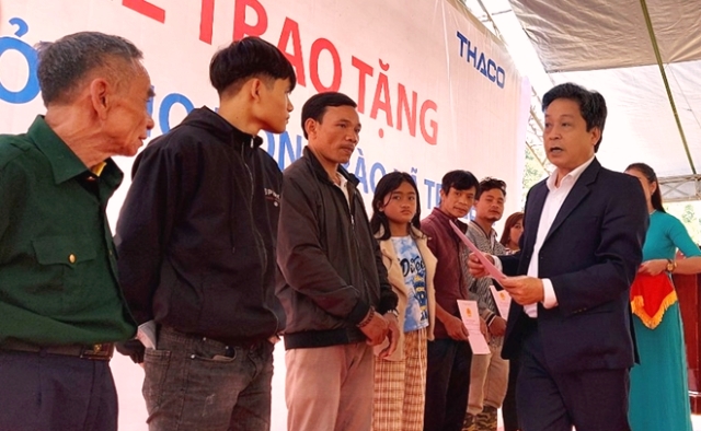 Ông Trần Duy Dũng, Chủ tịch UBND huyện Nam Trà My, bàn giao giấy tờ nhà mới cho người dân nóc Ông Đề.