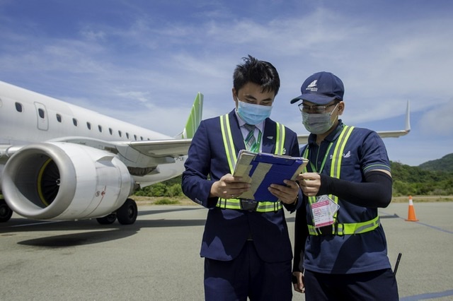Anh Trần Hữu Tài (bên phải) đang cùng với thợ kỹ thuật kiểm tra chuyến bay