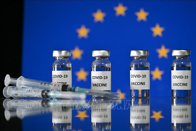 Cờ Liên minh châu Âu và vaccine phòng dịch COVID-19. Ảnh: AFP/TTXVN