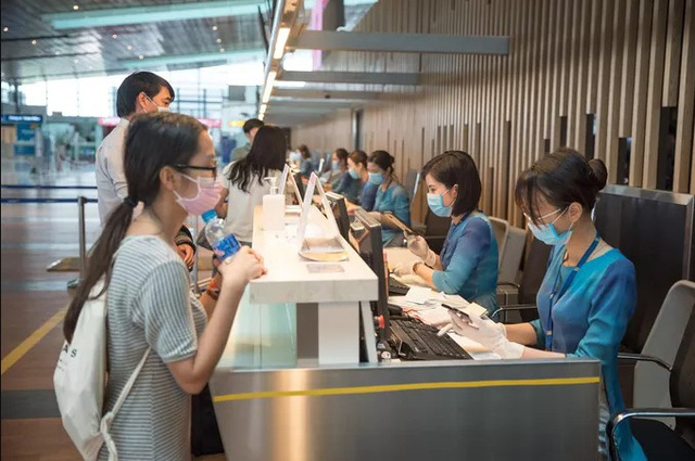 Hành khách qua sân bay Vân Đồn được yêu cầu thực hiện các biện pháp phòng dịch. (Ảnh: NLĐ)
