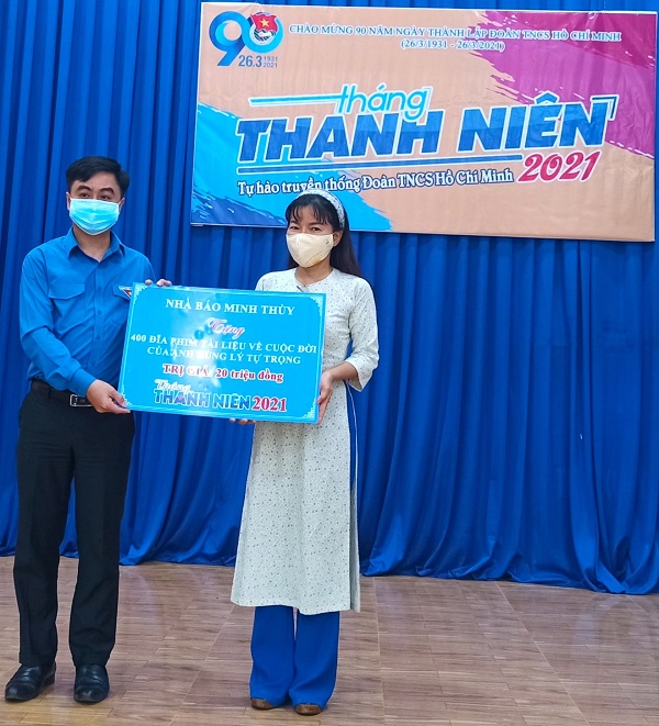 Nhà báo Minh Thùy (phải) trao bảng tượng trưng 400 đĩa phim tài liệu mang tên “Người truyền lửa” cho Bí thư Tỉnh Đoàn Bình Phước Trần Quốc Duy (trái)