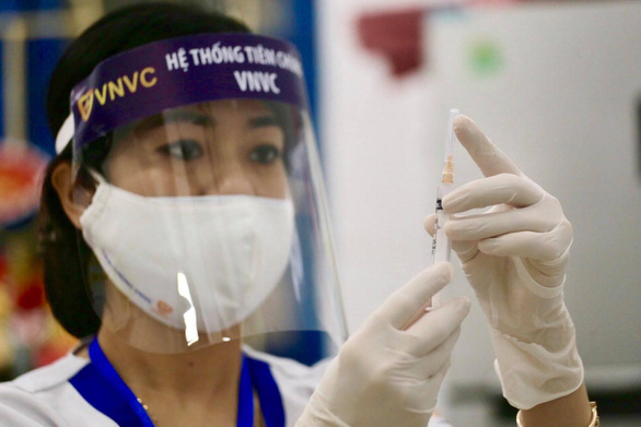 Nhân viên y tế kiểm tra kim tiêm trước khi tiêm vaccine ngừa COVID-19
