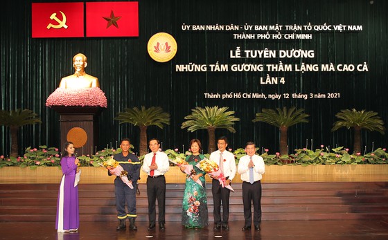 Bí thư Thành ủy TPHCM Nguyễn Văn Nên và Chủ tịch UBND TPHCM Nguyễn Thành Phong tặng hoa cho các tấm gương thầm lặng mà cao cả tại buổi lễ.