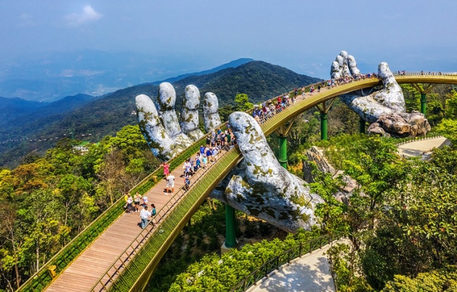 Cầu Vàng (cầu bàn tay) với kiến trúc độc đáo được khánh thành năm 2018 tại Đà Nẵng. Cây cầu dài 150 m, có độ cao 1.441m so với mực nước biển và mang điểm nhấn là hai đôi bàn tay đây rêu phong “đỡ” cây cầu. Cầu Vàng đã trở thành địa điểm chụp ảnh yêu thích của du khách khi đến Đà Nẵng. Ảnh: Daily Mail