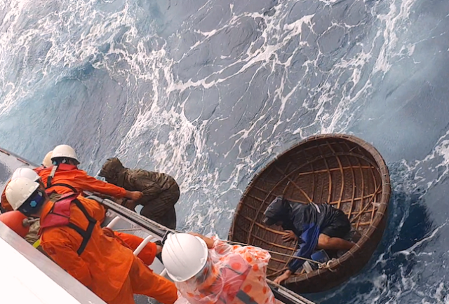 Các ngư dân được đưa từ thuyền thúng lên tàu cứu hộ .