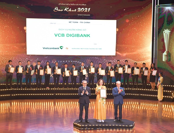 Bà Nguyễn Thị Kim Oanh – Phó Tổng giám đốc Vietcombank nhận Giấy chứng nhận và Cup vinh danh từ ông Phan Tâm – Thứ trưởng Bộ Thông tin và Truyền thông (bên trái) và ông Mai Liêm Trực - nguyên Thứ trưởng Bưu chính Viễn thông, là Chủ tịch Hội đồng Sao Khuê 2021 (bên phải)