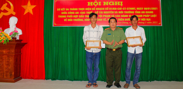 Đại tá Đinh Văn Nơi - giám đốc Công an tỉnh An Giang trao giấy khen cho hai người dân tố giác nhập cảnh trái phép - Ảnh: QUỲNH NHƯ