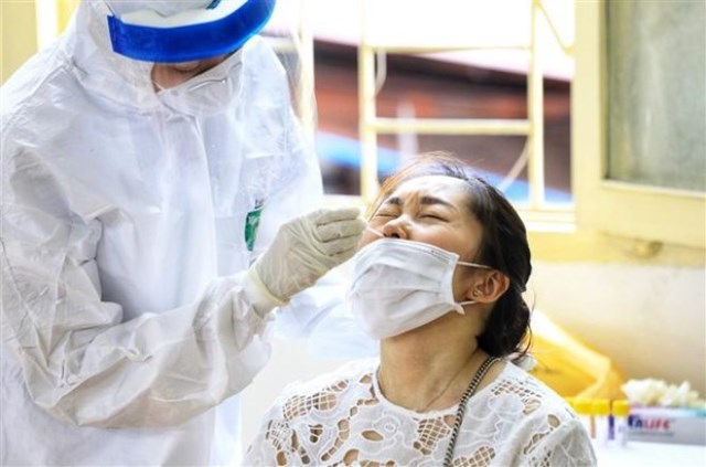 Nhân viên y tế quận Hoàn Kiếm tiến hành lấy mẫu xét nghiệm Covid-19 cho người dân từ Đà Nẵng trở về.