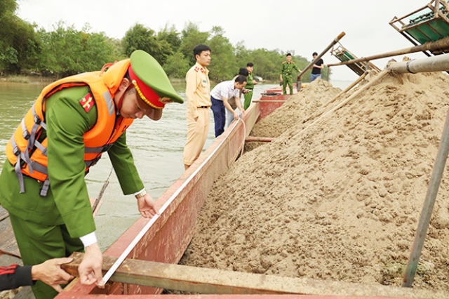 ực lượng chức năng tiến hành kiểm đếm khối lượng cát mà sà lan của ông Nguyễn Văn Bẩy khai thác trái phép
