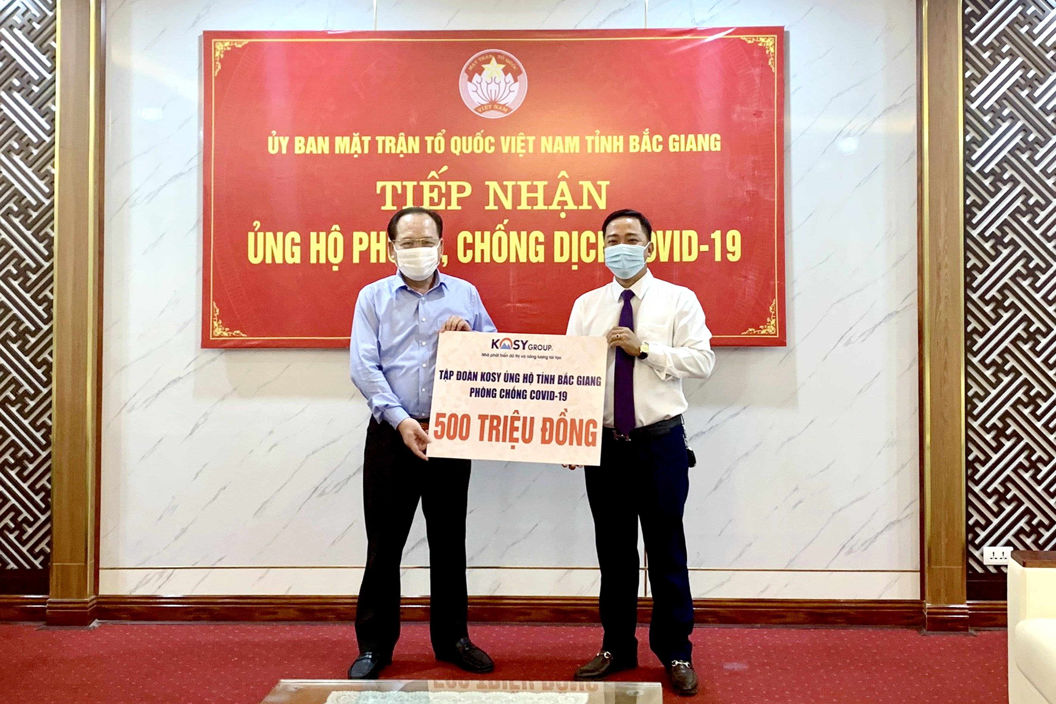 Ông Nguyễn Văn Sơn – Giám đốc Ban Quản lý dự án các khu đô thị của Tập đoàn Kosy tại Bắc Giang (bên phải) trao 500 triệu đồng ủng hộ công tác phòng chống dịch Covid-19 cho ông Trần Công Thắng – Chủ tịch Ủy ban Mặt trận Tổ quốc tỉnh Bắc Giang (bên trái)