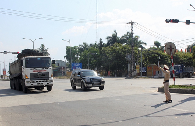 Tại chốt kiểm so&aacute;t dịch tr&ecirc;n quốc lộ 14B, lưu lượng phương tiện giao th&ocirc;ng qua lại rất nhiều n&ecirc;n lực lượng c&ocirc;ng an phải l&agrave;m việc li&ecirc;n tục dưới tiết trời nắng n&oacute;ng