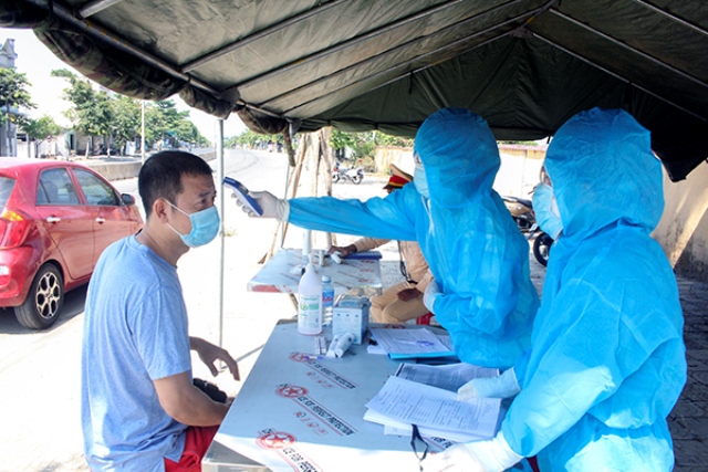 C&aacute;c t&agrave;i xế v&agrave; người tr&ecirc;n xe được lực lượng y tế đo th&acirc;n nhiệt, hướng dẫn khai b&aacute;o y tế khi qua chốt