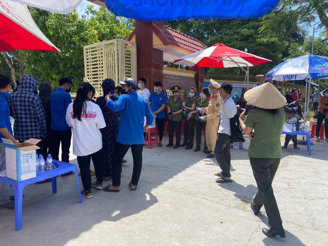 Các tình nguyện viên cùng lực lượng CSGT huyện Nghi Lộc hướng dẫn phát khẩu trang, nước miễn phí cho các thí sinh tại điểm trường nghi Lộc 5