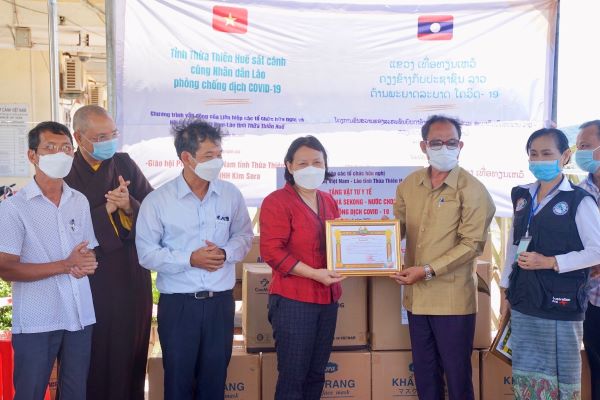 Bà Trần Thị Mai (áo đó) trao tặng trang thiết bị y tế cho nước bạn Lào