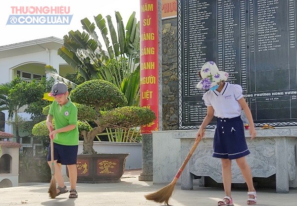 Thầy và trò nhà trường quét dọn và thắp hương tại tượng đài liệt sỹ phường Hùng Vương
