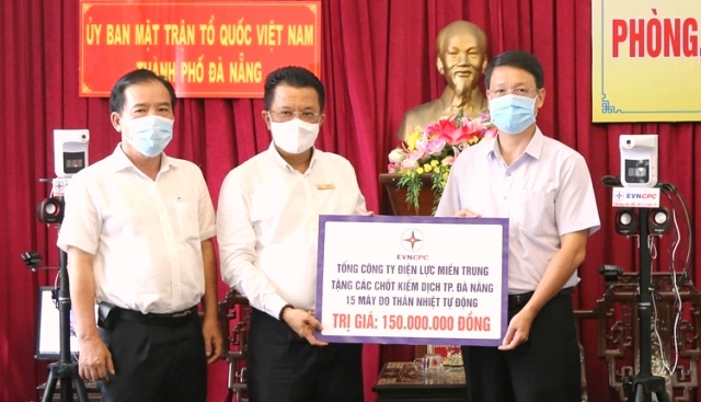 Tổng Giám đốc EVNCPC Ngô Tấn Cư (bên trái) trao bảng tượng trưng kinh phí hỗ trợ mua vaccine và 15 máy đo thân nhiệt tự động.