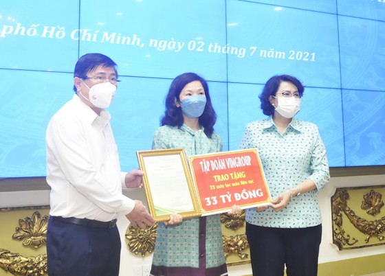 Chủ tịch UBND TPHCM Nguyễn Thành Phong và Chủ tịch Ủy ban MTTQ Việt Nam TPHCM Tô Thị Bích Châu tiếp nhận bảng tượng trưng tặng trang thiết bị y tế của đại diện Tập đoàn Vingroup. Ảnh: CAO THĂNG