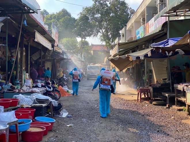 Nhân viên y tế phun khử khuẩn tại chợ xã Lộc Điền, huyện Lộc Ninh