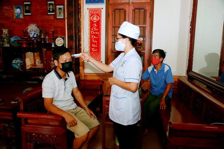 Cán bộ y tế xã Đồng Cương, huyện Yên Lạc kiểm tra thân nhiệt đối với các trường hợp đang cách ly tại nhà khi đi về từ vùng dịch. Ảnh: Trà Hương