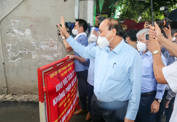 Chủ tịch nước Nguyễn Xuân Phúc hỏi thăm người dân tại một khu phong tỏa ở khu phố 1, thị trấn Hóc Môn, huyện Hóc Môn, TP.HCM