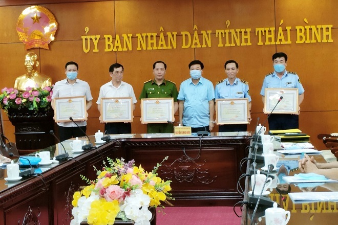 Phó chủ tịch thường trực UBND tỉnh, Trưởng BCĐ 389 Thái Bình, Nguyễn Quang Hưng (thứ 3 bìa phải) trao tặng Bằng khen các tập thể, cá nhân có thành tích xuất sắc trong công tác chống buôn lậu và phòng chống dịch Covid-19