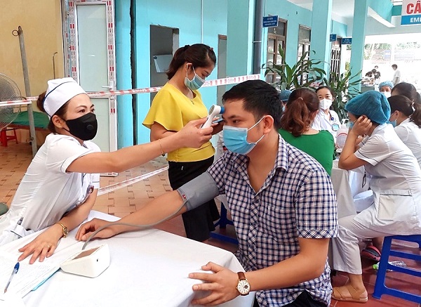 Cán bộ y tế khám sàng lọc trước khi tiêm vắc-xin phòng Covid-19 cho người dân ở thành phố Hà Giang