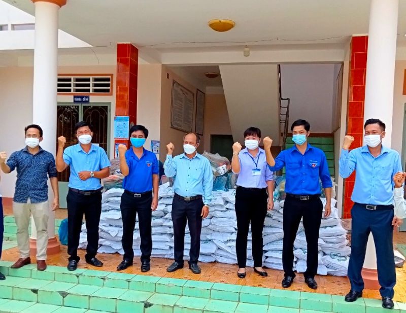 Anh Phạm Khắc Học - Giám đốc Công ty TNHH Bất động sản Kiên Cường Phát (bìa phải) và anh Nguyễn Thành - Phó tổng giám đốc Tập đoàn Kavi Group (bìa trái) trao các suất quà cho UBND xã Lộc Thịnh (H.Lộc Ninh)