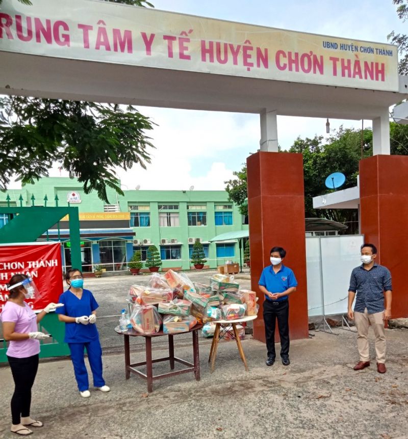 Bí thư Tỉnh Đoàn Bình Phước Trần Quốc Duy (thứ 2, phải sang) và anh Nguyễn Thành - Phó tổng giám đốc Tập đoàn Kavi Group (bìa phải) động viên tuyến đầu chống dịch tại khu vực điều trị COVID-19 (Trung tâm Y tế huyện Chơn Thành)