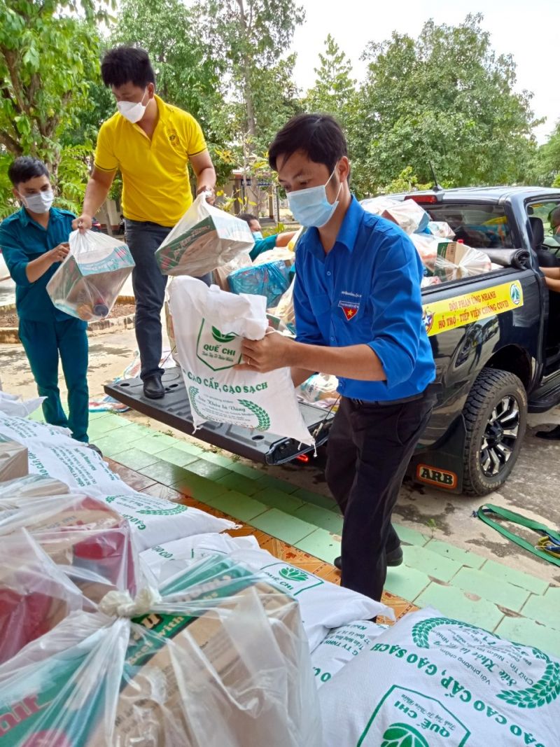 Thanh niên huyện biên giới Lộc Ninh cùng các thành viên đội phản ứng nhanh Sao Nhân Ái hăng hái khuân vác nhu yếu phẩm xuống xe