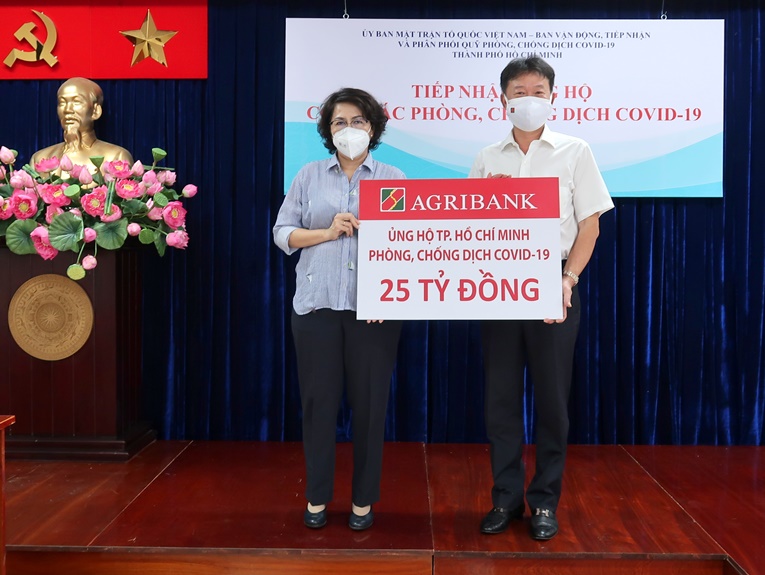 Đại diện Agribank (bên phải) trao tặng ủng hộ cho đại diện Mặt trận Tổ quốc TPHCM