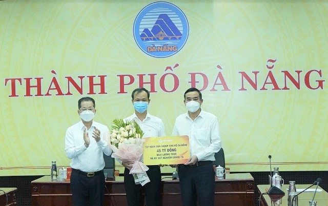 Bí thư Thành ủy Nguyễn Văn Quảng (bìa trái) tặng hoa cảm ơn đại diện Tập đoàn Sun Group (giữa) và Chủ tịch UBND thành phố Đà Nẵng Lê Trung Chinh (bìa phải) nhận ủng hộ của doanh nghiệp.