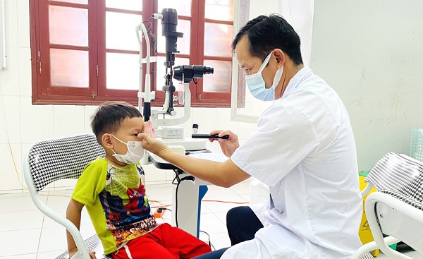 Bác sỹ Trung tâm Y tế huyện khám sàng lọc cho trẻ khuyết tật về mắt