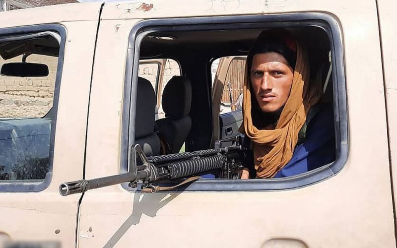 Chiến binh Taliban cầm súng ngồi trong xe lấy được của đối phương. Ảnh: AFP.