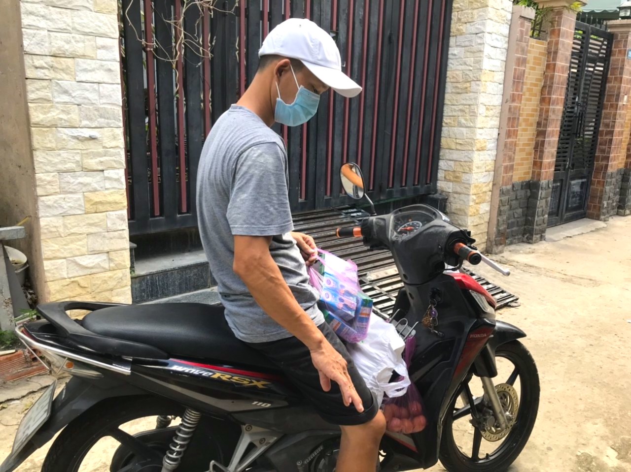 Một nam thanh niên ở quận 7 (TP Hồ Chí Minh) đang xếp quà từ chuyến xe yêu thương thứ 9 của thanh niên Bình Phước lên xe máy, nhanh chóng chở về nhà