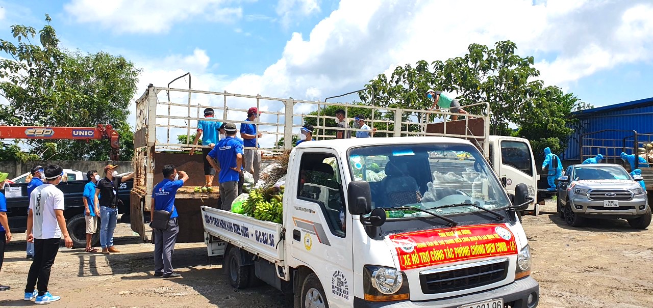 Thanh niên 2 tỉnh Bình Dương - Bình Phước đang khuân vác nông sản và nhu yếu phẩm lên chuyến xe nghĩa tình thứ 8 hướng về vùng dịch Bình Dương