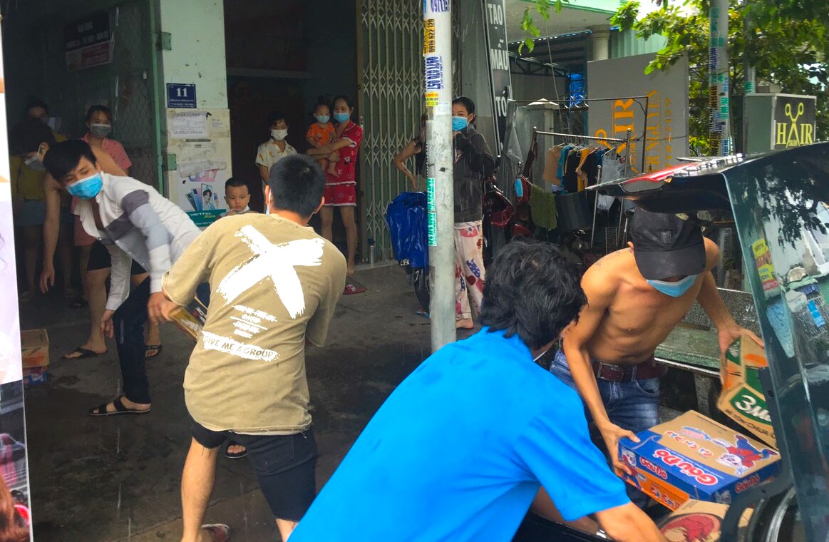 Các tình nguyện viên nhanh chóng chuyền tay nhau những phần quà thắm nghĩa tình Sông Bé để “tiếp sức” các công nhân gặp khó khăn ở khu nhà trọ tại TP Thuận An (Bình Dương)