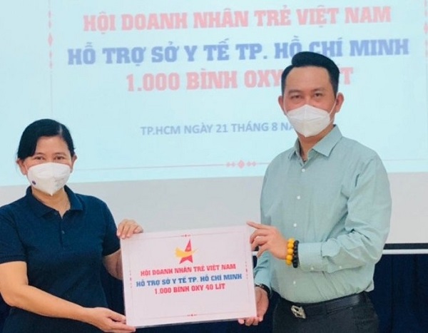 Chủ tịch Hội Doanh nhân trẻ Việt Nam Đặng Hồng Anh (phải) trao biển tượng trưng tặng 1.000 bình Oxy 40 lít cho đại diện Sở Y tế TP. Hồ Chí Minh
