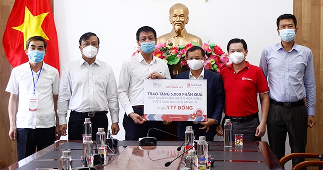 Lãnh đạo huyện Hòa Vang (bên trái) tiếp nhận hỗ trợ của Tập đoàn BRG và Ngân hàng SeABank sáng 22/8.