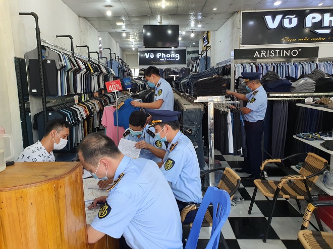 Lực lượng chức năng đang tiến hành kiểm kê số hàng hóa vi phạm tại Cửa hàng Vũ Phong