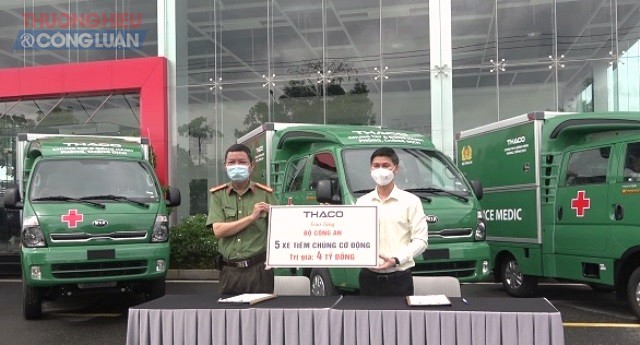 Thừa ủy quyền của Bộ Công an, đại diện Bệnh viện 199 (trái) tiếp nhận 5 xe tiêm chủng lưu động do Thaco Auto tài trợ.