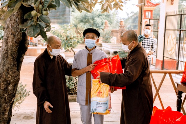 Hoà thượng Thích Thế Trang (bên trái) và Đại đức Thích Nhật Tuệ (bên phải) tặng quà cho người dân nhân ngày 