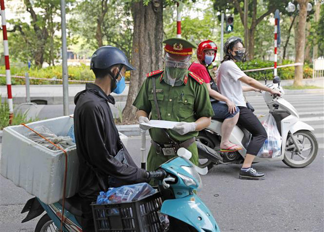 Đội kiểm soát cơ động Công an quận Hoàn Kiếm kiểm tra giấy đi đường của người dân trên phố Lê Thái Tổ