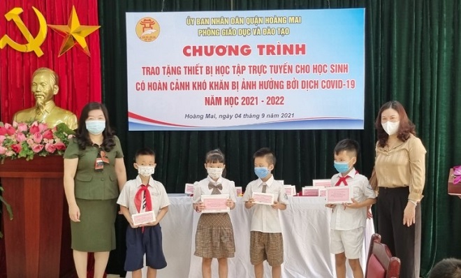 Lãnh đạo Phòng GD&ĐT quận Hoàng Mai trao các thiết bị học tập trực tuyến cho các em học sinh có hoàn cảnh khó khăn.