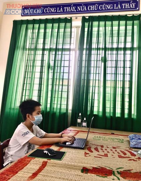 Cháu Hoàng Hữu Gia Phúc, học sinh lớp 4, Trường Tiểu học Đinh Bộ Lĩnh, tổ 19, phường Tam Thuận cùng bố mẹ, anh trai tại khu cách ly tại Trường Tiểu học An Khê theo dõi buổi khai giảng trực tuyến