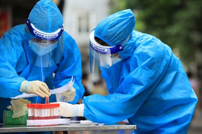 Lực lượng y tế lấy mẫu xét nghiệm SARS-CoV-2 cho người dân. (Nguồn: laodong.vn)