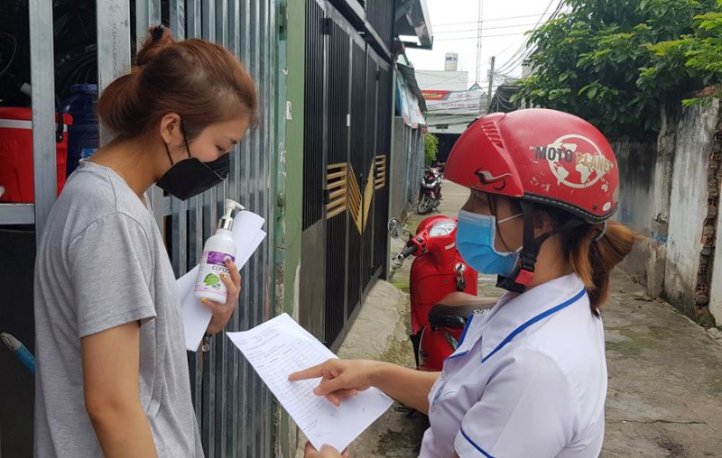 Nhân viên Trạm Y tế Trảng Dài, TP. Biên Hòa đến các hộ gia đình hướng dẫn người dân tự theo dõi sức khỏe tại nhà để phòng chống dịch COVID-19.