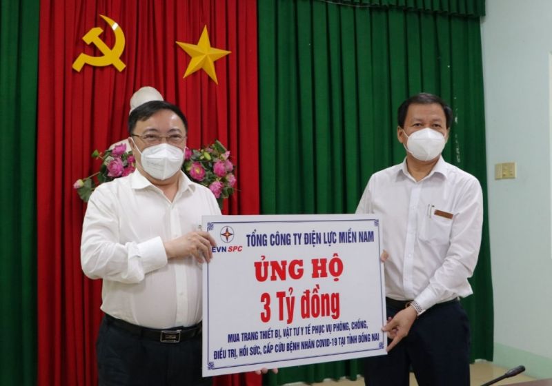 Đại diện PC Đồng Nai (bên phải) thay mặt EVNSPC trao biểu trưng 3 tỉ đồng cho Sở Y tế Đồng Nai