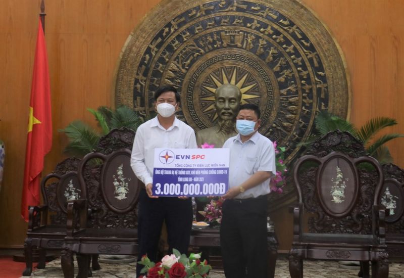 hủ tịch UBND tỉnh Long An Nguyễn Văn Út (bên phải) tiếp nhận nguồn kinh phí hỗ trợ công tác phòng chống dịch do đại diện Cty Điện lực Long An thay mặt EVNSPC trao.